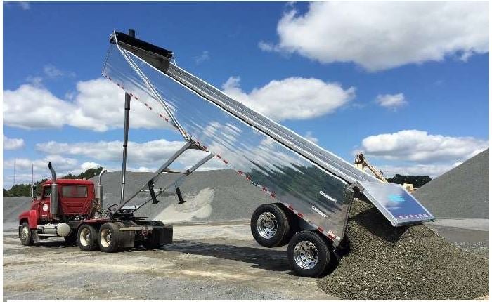 Dump trailer delivering construction aggregate