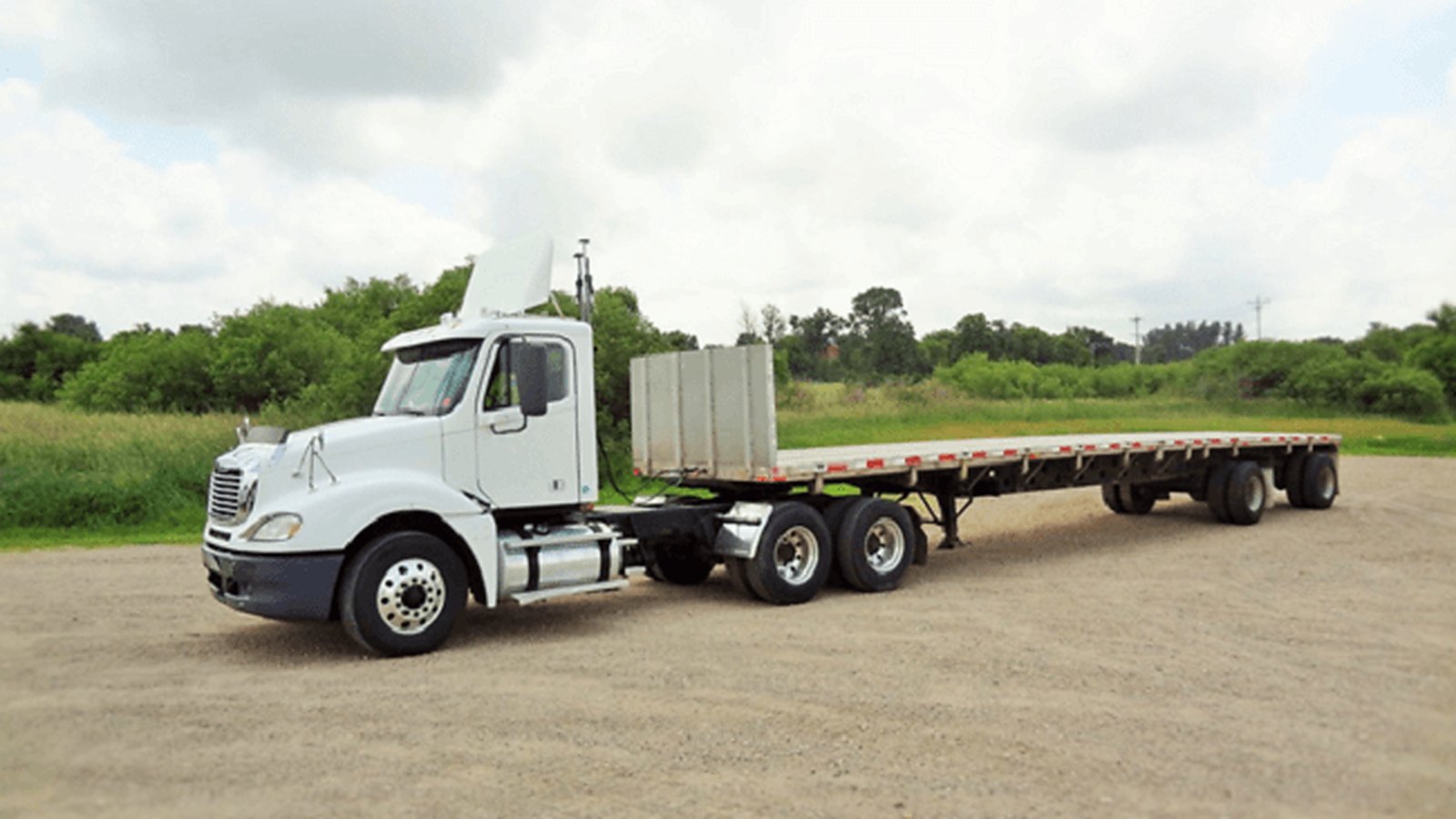 Flatbed tractor-trailer with an open deck ready to load