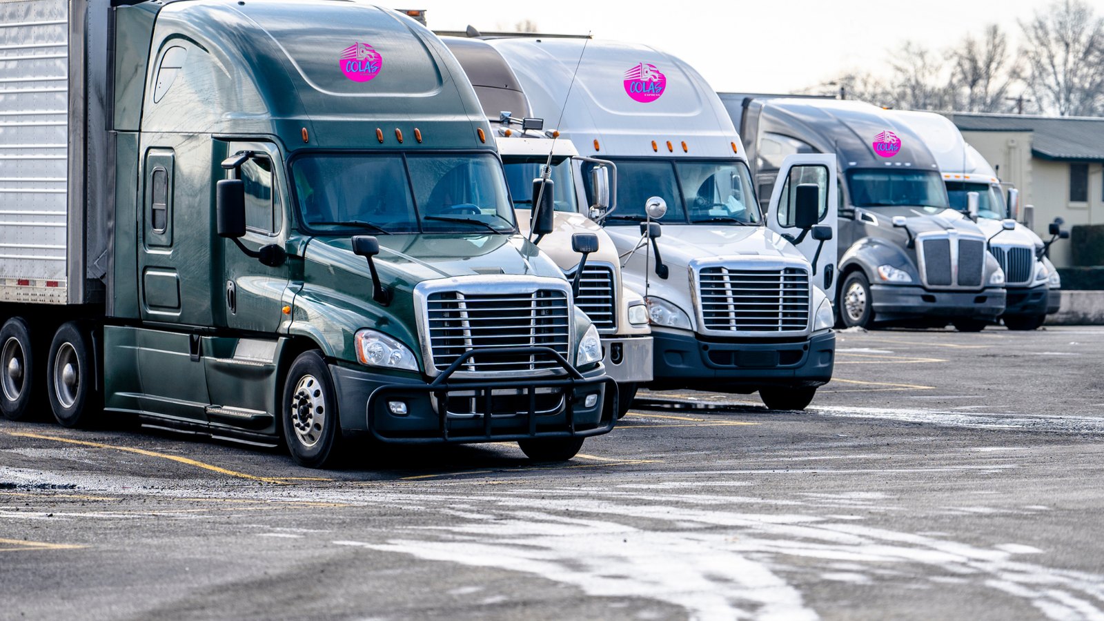 A row of tractors staged at a freight terminal